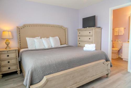a bedroom with a bed with a dresser and a television at Sea Pond Villa Unit 3 in Myrtle Beach