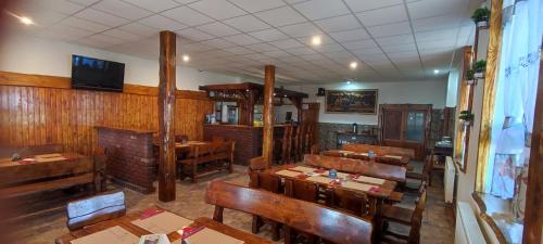 a restaurant with wooden tables and benches in a room at Ubytování v klimatizovaných chatičkách Štít in Chlumec nad Cidlinou