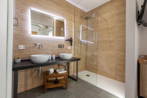 a bathroom with two sinks and a shower at Oneira Rooms in Agrigento