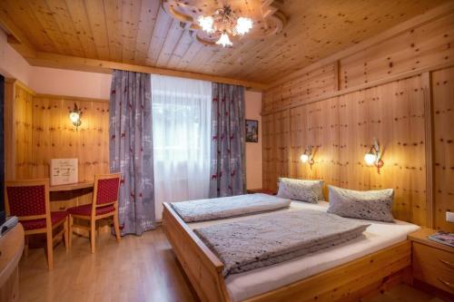 a bedroom with a bed and a desk in it at Pension Alpengruss in Gerlos
