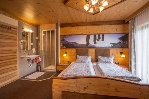 a bedroom with a large bed in a room at Pension Alpengruss in Gerlos