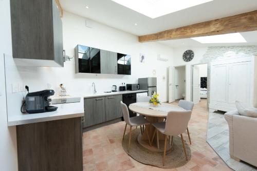 a kitchen and living room with a table and chairs at Le Lavandin classé 3 étoiles in Riez