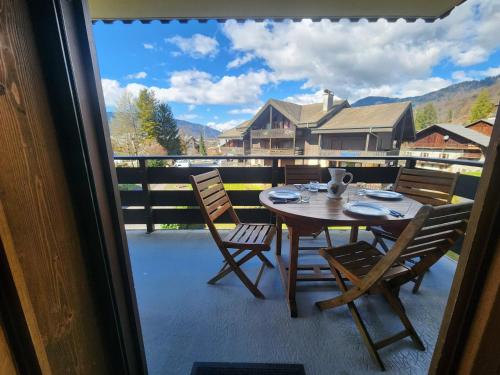 une table et des chaises sur un balcon avec vue dans l'établissement Appartement 3 pièces au centre de Samoëns avec garage, balcon et WIFI - FR-1-629-101, à Samoëns