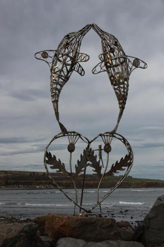 a metal heart statue sitting on top of some rocks at Shorehead Guest House in Stonehaven