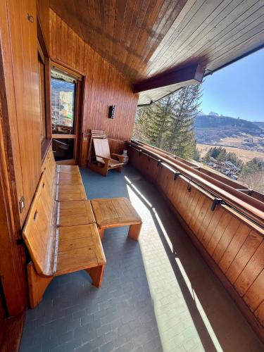 a room with benches and a window in a building at Elegant Apartment with center and Tofana view in Cortina dʼAmpezzo