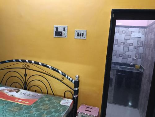 a bedroom with a bed and a yellow wall at Aliya in Kolkata