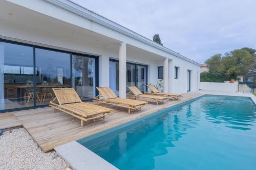 un patio avec des chaises et une piscine dans l'établissement La Villa J, à Aubagne