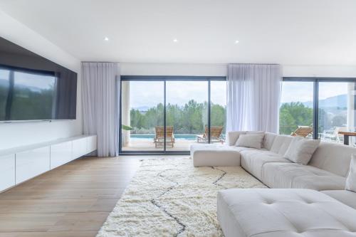 un salon avec un canapé blanc et une télévision dans l'établissement La Villa J, à Aubagne