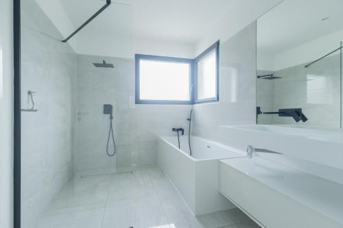 La salle de bains blanche est pourvue d'une douche, d'une baignoire et d'un lavabo. dans l'établissement La Villa J, à Aubagne