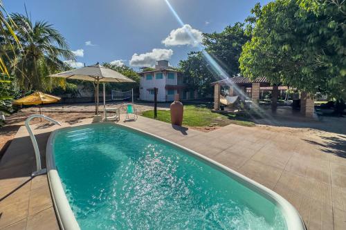 a swimming pool with a fountain in a yard at Amaly Pousada e Bistrô in Japaratinga