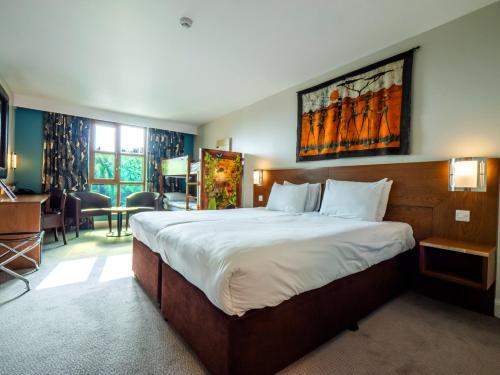 a hotel room with a large bed and a desk at Chessington Resort Hotel in Chessington