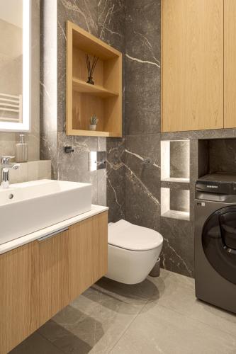 a bathroom with a toilet and a sink at Brabank Emerald Luxury Apartment Fitness, Sauna & Parking by Grandview in Gdańsk