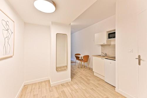Cet appartement blanc comprend une cuisine et une salle à manger. dans l'établissement Cozy and convenient studio in Asnières-sur-Seine-V, à Asnières-sur-Seine
