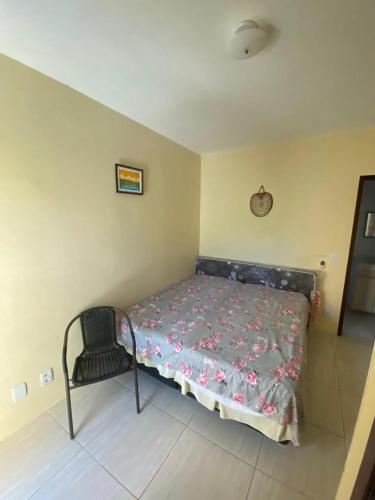 a bedroom with a bed and a chair in it at Casa em Imbassai in Imbassai
