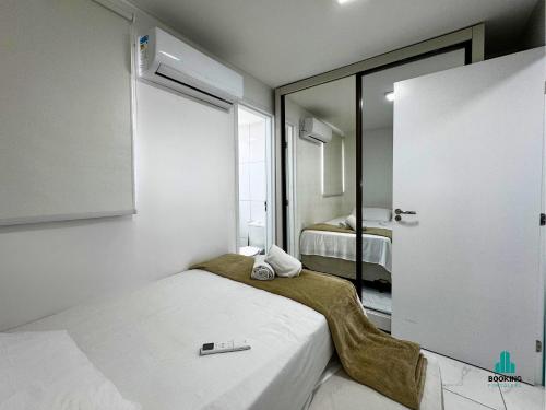 a small room with a bed and a mirror at Aquarius Residence by Holiday Stays in Fortaleza