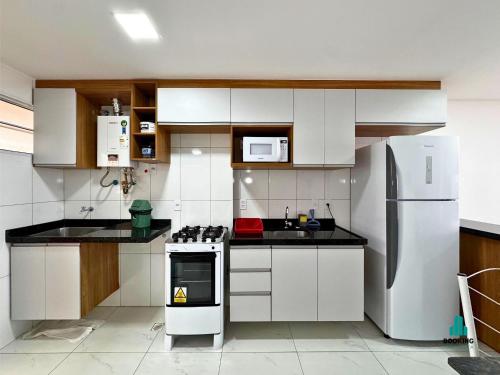 a kitchen with white cabinets and a refrigerator at Aquarius Residence by Holiday Stays in Fortaleza