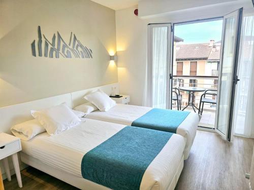 a hotel room with two beds and a balcony at Pensión Txiki Polit in Zarautz