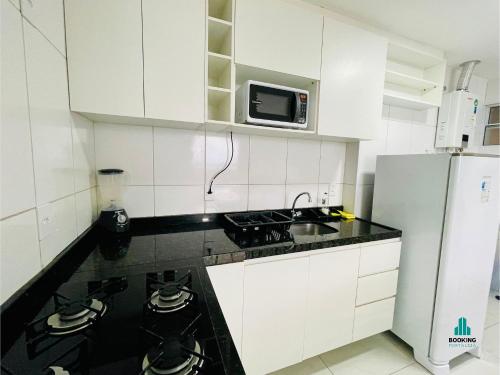 a kitchen with white cabinets and a white refrigerator at Aquarius Residence by Holiday Stays in Fortaleza