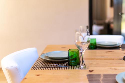 a wooden table with a plate and a wine glass at Villa Anna - Havre de paix in Oulad Ikhia