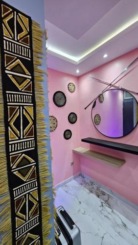 a room with pink walls and a mirror at F2 équipé à Fann Hock in Dakar