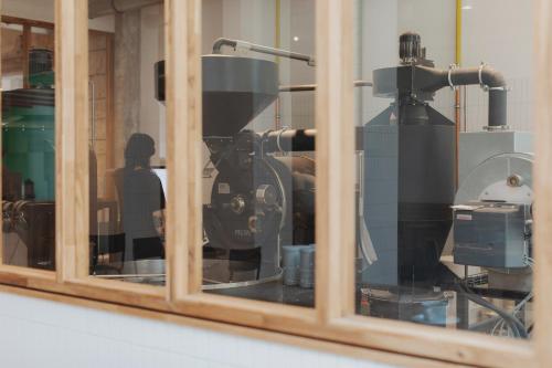 a glass window with a machine in a room at Man Met Bril Koffie Hotel in Rotterdam