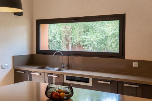 a kitchen with a sink and a large window at Villa Anna - Havre de paix in Oulad Ikhia