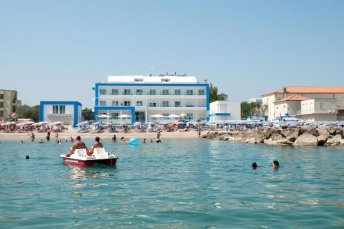 a group of people in the water at a beach at Lungomare Relax Residence in Misano Adriatico