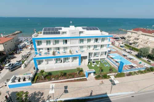 a large building with a pool in front of the ocean at Lungomare Relax Residence in Misano Adriatico