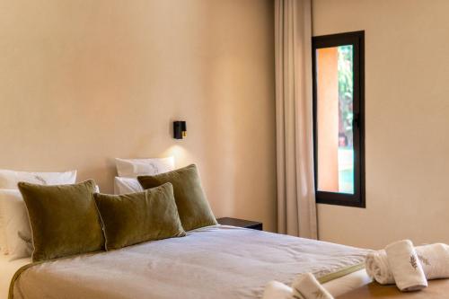a bedroom with a large white bed with a window at Villa Anna - Havre de paix in Oulad Ikhia