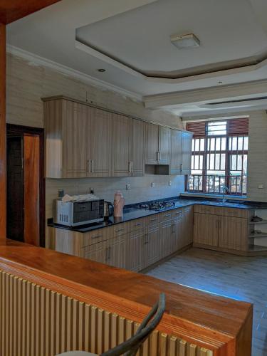 una grande cucina con mobili in legno e un forno a microonde di Davi apartment a Kigali