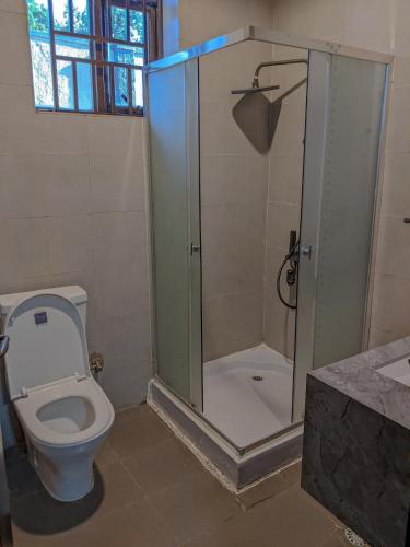 un bagno con doccia, wc e lavandino di Davi apartment a Kigali