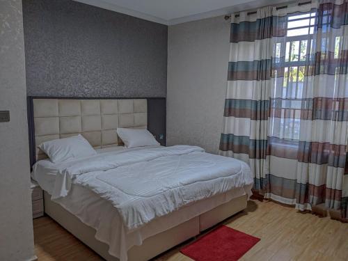 una camera da letto con un letto e una finestra di Davi apartment a Kigali