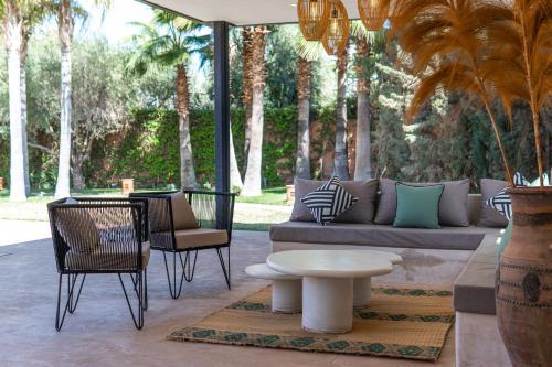 a patio with a couch and chairs and a table at Villa Anna - Havre de paix in Oulad Ikhia