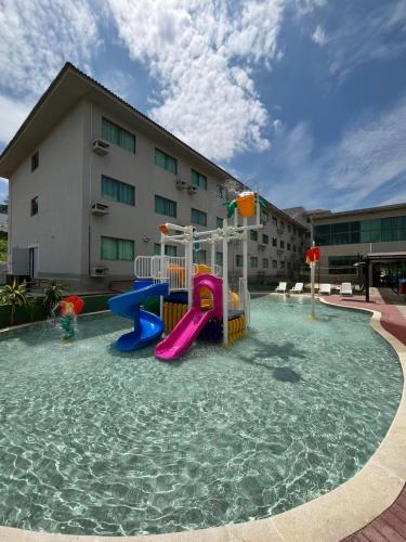 a pool with a slide in the water in front of a building at Hotel Golden Park Sorocaba & Convenções by Nacional Inn in Sorocaba