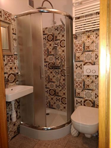 een badkamer met een douche, toilet en wastafel bij Stare Miasto in Olsztyn