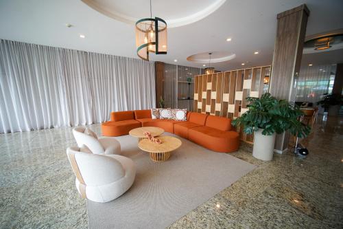 a living room with orange couches and a table at Hotel Golden Park Sorocaba & Convenções by Nacional Inn in Sorocaba