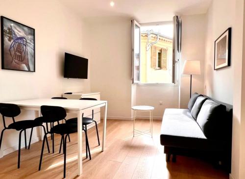 een woonkamer met een tafel, stoelen en een bank bij Collet Résidence in Nice