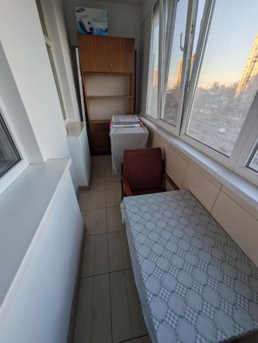 ein Zimmer mit zwei Fenstern und einem Stuhl darin in der Unterkunft Dacia in Chişinău