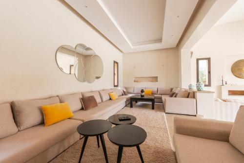 a living room with a couch and two tables at Villa Anna - Havre de paix in Oulad Ikhia
