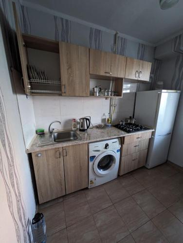 eine Küche mit Spüle und Waschmaschine in der Unterkunft Dacia in Chişinău