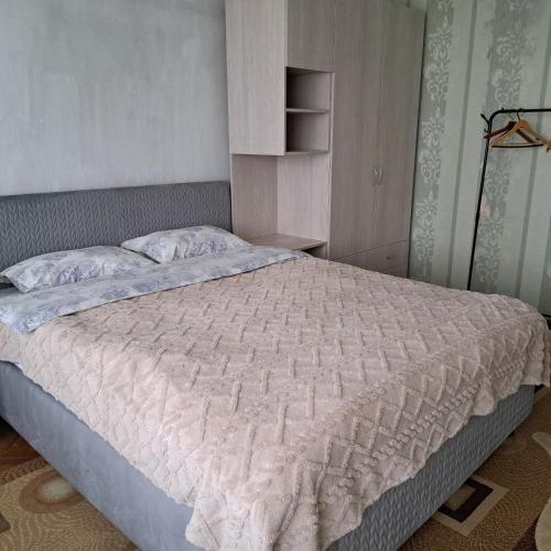 ein Schlafzimmer mit einem großen Bett und einer weißen Bettdecke in der Unterkunft Dacia in Chişinău