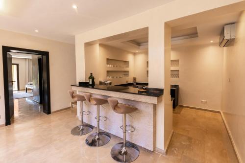 a kitchen with a bar with stools at Villa Anna - Havre de paix in Oulad Ikhia