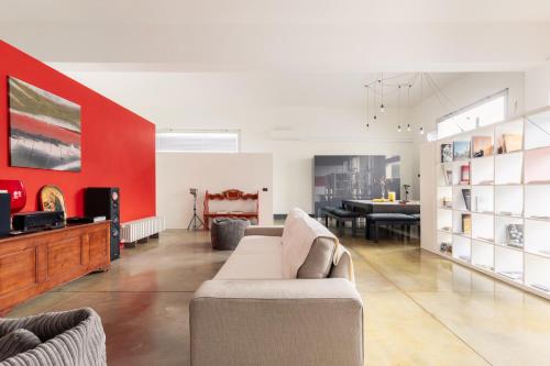 a living room with a couch and a red wall at Tuscany Crossroad in Empoli