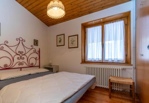 a bedroom with a large bed and a window at Ciasa al Sol in Falcade