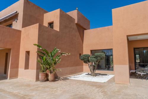 a building with potted plants in front of it at Villa Anna - Havre de paix in Oulad Ikhia