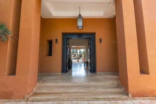 an empty hallway of a house with orange walls and columns at Villa Anna - Havre de paix in Oulad Ikhia