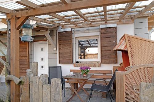 a patio with a wooden pergola and a wooden table at Ferienwohnung 'an der Ostsee' in Mechelsdorf