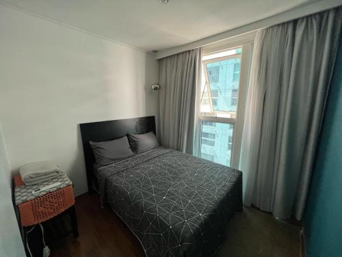 a small bedroom with a bed and a window at Flat em Santos no Gonzaga a três quadras da praia in Santos