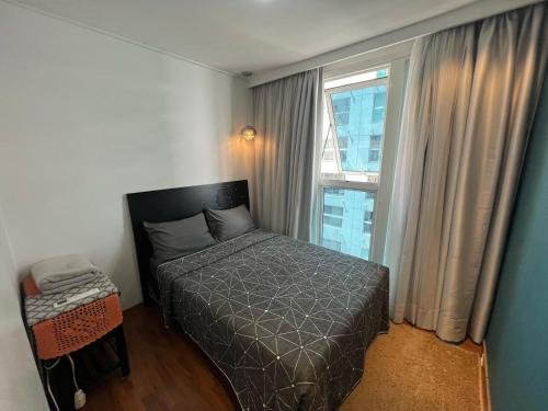 a small bedroom with a bed and a window at Flat em Santos no Gonzaga a três quadras da praia in Santos