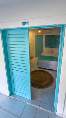 a door leading into a bedroom with a bed at Amaly Pousada e Bistrô in Japaratinga